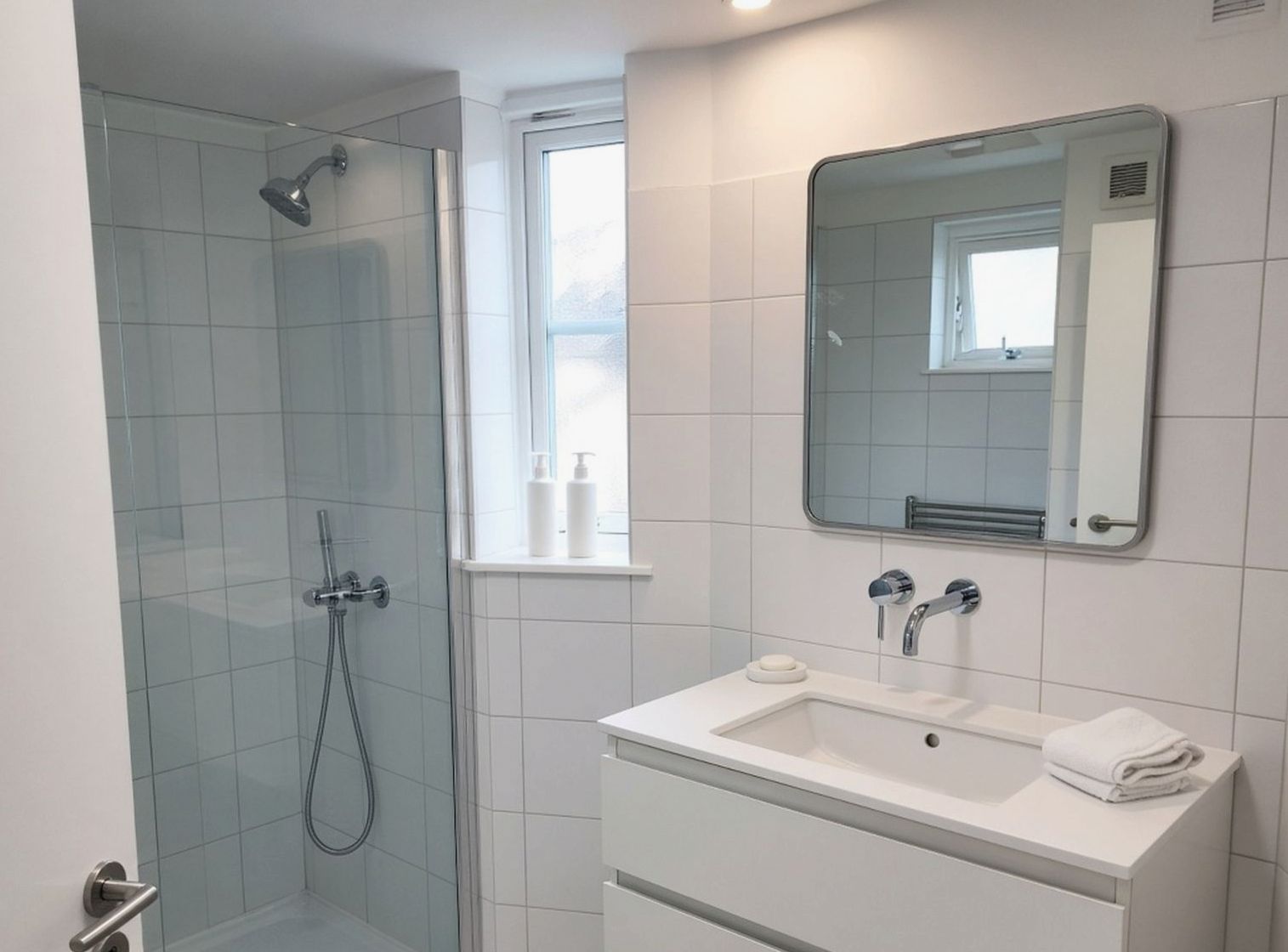 Small hotel bathroom with a folded towel on the rail